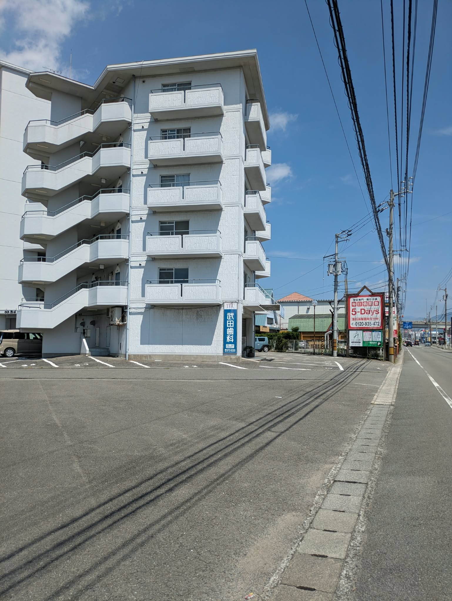 武田歯科の看板があるマンションと駐車場の進入口