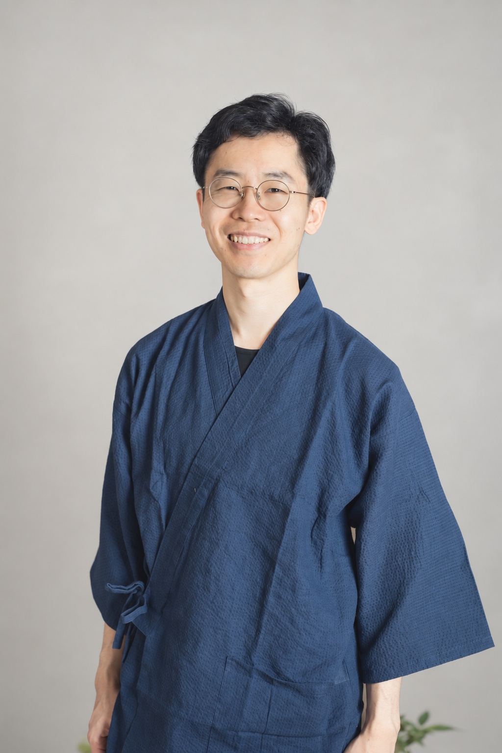 紺色の施術着を着た院長・尾上航さん