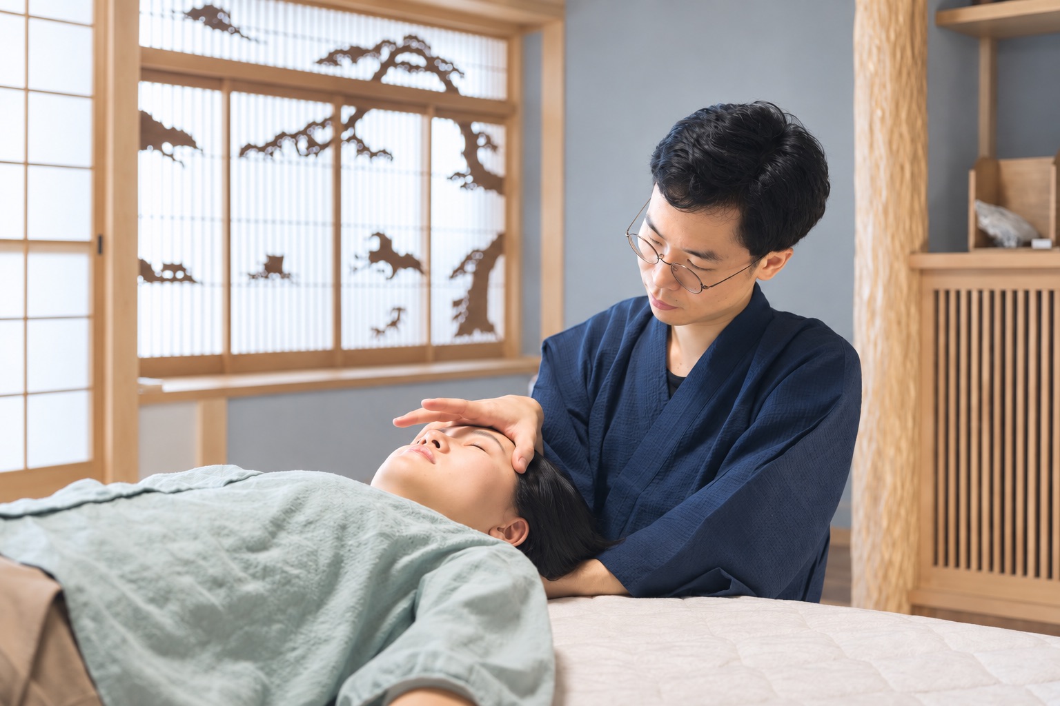施術ベッドで頭部に手を添える様子